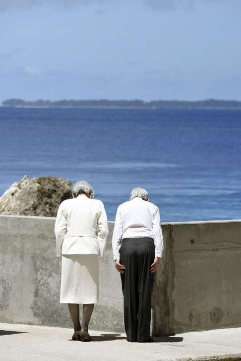 Japan's Emperor Akihito and Empress Michiko bow toward Angaur island after offering flowers at the cenotaph on Pelelilu island in Palau last year. Photo: AP