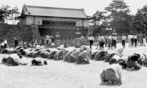 Japanese people kneel in front of the Imperial Palace in Tokyo as Emperor Hirohito announces on radio that Japan has been defeated in the second world war. Photo: Kyodo