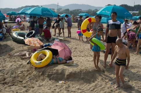 Holidaymakers stand on a beach in Beidaihe. Photo: AFP