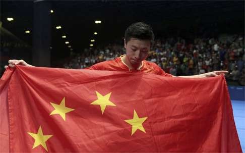 Ma poses with a Chinese national flag after winning the table tennis team final against Japan. Photo: Reuters
