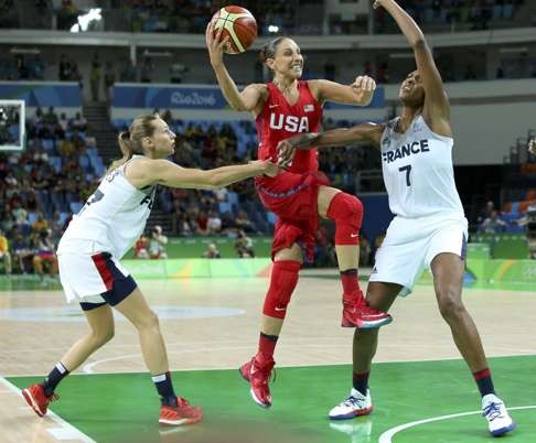 Marine Johannes of France (left) and teammate Sandrine Gruda battle with Diana Taurasi of the US. Photo: Reuters
