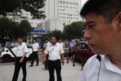 Chinese men in plain clothes, believed to be security personnel, follow journalists outside the No 2 Intermediate People's Court in Tianjin, where activists and lawyers were tried earlier this month. Photo: EPA