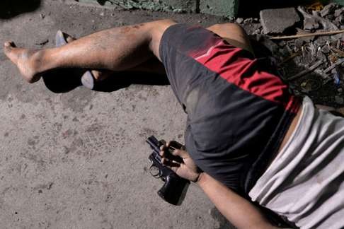The body of a man is pictured with a gun under his hand, whom police said was killed during a drug bust operation in Manila. Photo: Reuters