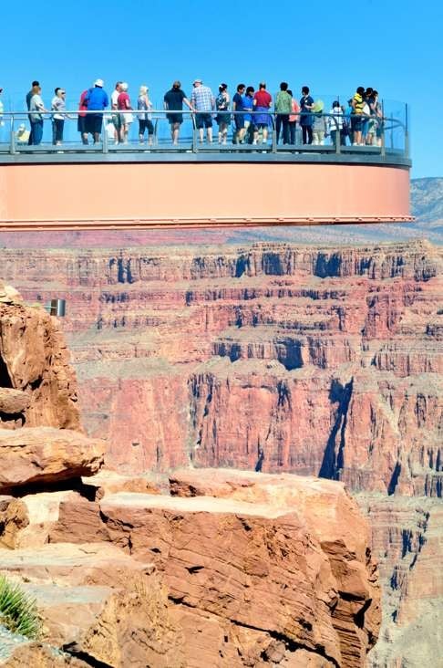 Visitors look down at the Grand Canyon through the transparent floor of the Skywalk.