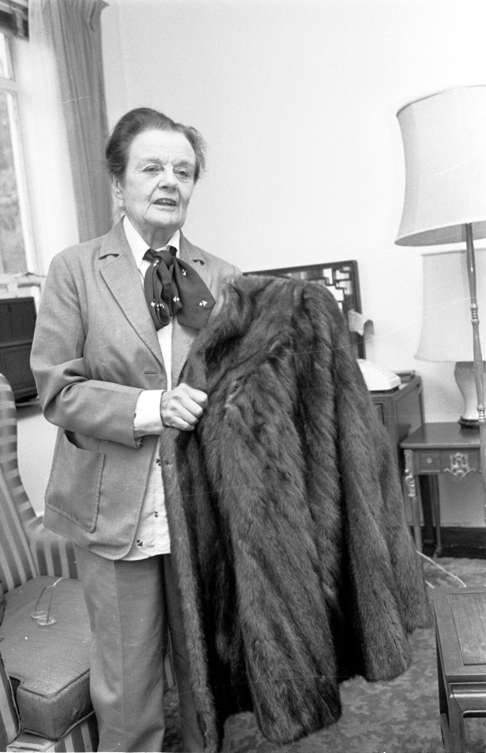 Clare Hollingworth holds up a mink coat that once belonged to Melinda Maclean, the wife of British spy Donald Maclean who defected to the Soviet Union. She was the Macleans' neighbour in England, and Melinda's mother gave it to her for safe keeping. Picture: SCMP