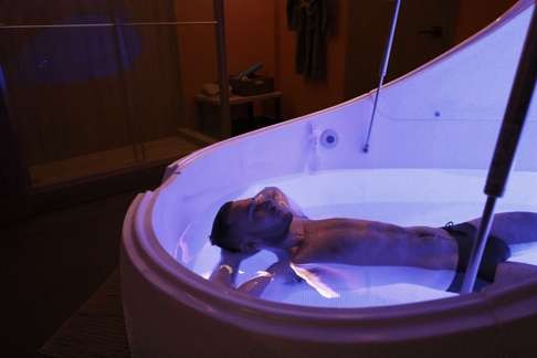 A model relaxes in a flotation tank at Zero Gravity Floatation.