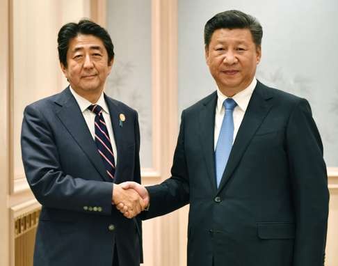 Chinese President Xi Jinping (right) and Japanese Prime Minister Shinzo Abe shake hands ahead of their talks in Hangzhou on September 5, 2016. Photo: Kyodo
