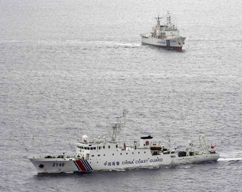 A Chinese coastguard vessel (front) sails near a Japanese coastguard vessel (rear) on August 15, 2013, south of Uotsuri island, one of a group of disputed islands, called the Senkakus in Japan and the Diaoyu in China, in the East China Sea. Photo: Reuters