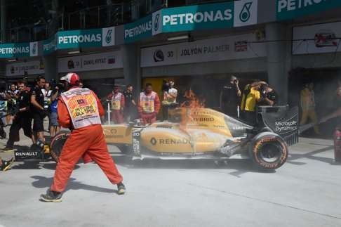 Kevin Magnussen’s car is engulfed in flames. Photo: AFP
