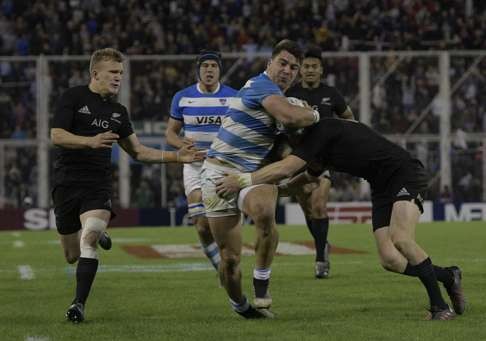 Argentina number eight Facundo Isa is tackled by New Zealand centre Ryan Crotty.