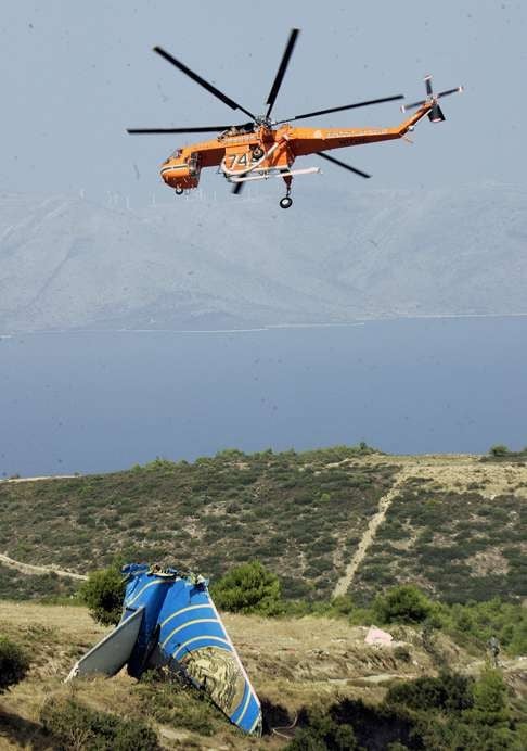 A helicopter flies over the tail section of crashed Helios Airways Flight 522. Photo: AFP