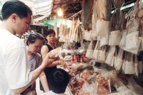 Customers look at salted fish in a dried seafood store in Tai O.