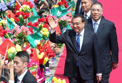 Premier Li Keqiang is greeted at Macau airport by Chief Executive of Macau Fernando Chui Sai-on (R). Photo: Dickson Lee