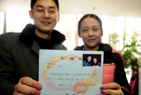 He Shaodong and his wife Zhou Jun show their birth certificate for a second child in Hefei, Anhui province, on February 14, 2014, when the province relaxed the one-child policy a month earlier. Photo: Xinhua