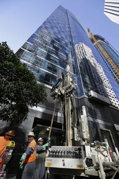 Engineers install data collection devices and obtain soil samples outside the Millennium Tower in San Francisco.Photo: AP