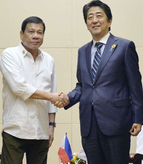 Japanese Prime Minister Shinzo Abe (R) and Philippine President Rodrigo Duterte shake hands ahead of their talks in Vientiane, Laos in September. Photo: Kyodo