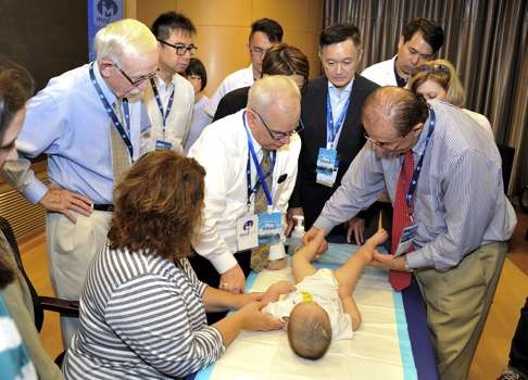 Doctors from Hong Kong, China and the US examine a baby with spina bifida at Suzhou Children's Hospital.