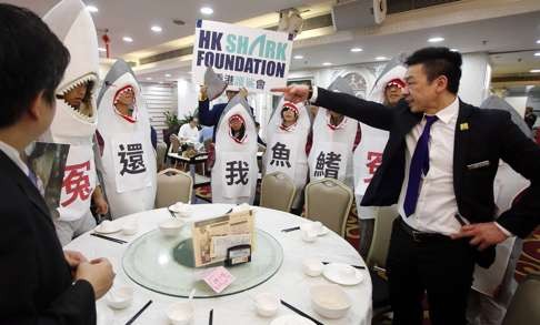 Protesters from WildAid Hong Kong and the Hong Kong Shark Foundation dress in shark costumes protest at a restaurant which exclusively serves shark’s fin. Photo: Sam Tsang