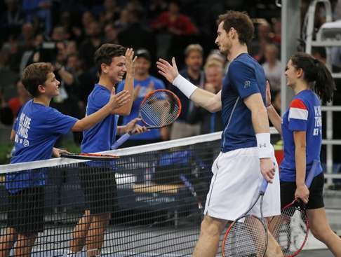 Britain's Any Murray shakes hands with ball boys and a ball girl after he played with them during a training session at the Paris Masters. Photo: AP