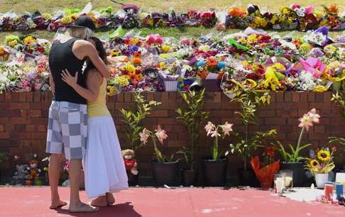 People leave floral tributes outside the main entrance to Dreamworld. Photo: Reuters