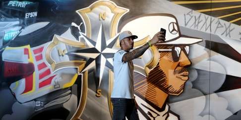 Mercedes’ Lewis Hamilton takes a selfie in front of a graffiti during a promotional event in Sao Paulo, Brazil. Photo: Reuters