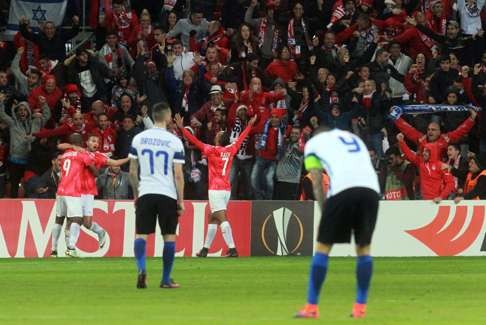 Hapoel players celebrate with their fans as Inter Milan players appear inconsolable. Photo: AFP