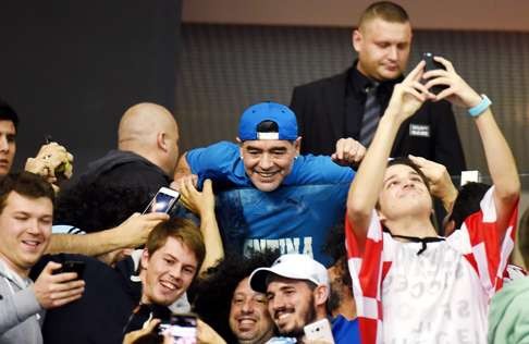 Argentina and Croatia fans take selfies with Argentinian legend Maradona. Photo: AFP