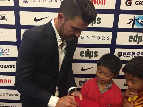 Villa autographs a shirt for a youngster.