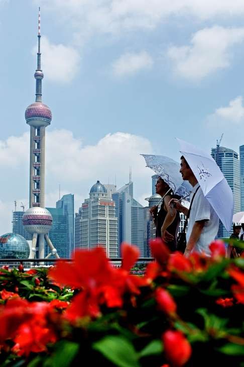 Tourists walk along the Bund in Shanghai. Globalisation, which has helped to lift millions out of poverty, has all but closed the GDP gap between emerging and developed economies. Photo: AFP