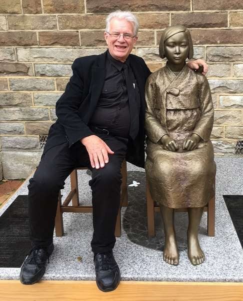 Uniting Church minister Bill Crews poses for a photo with a statue erected as a memorial to sex slaves of Japan's second world war army in Sydney, Australia. Photo:AP