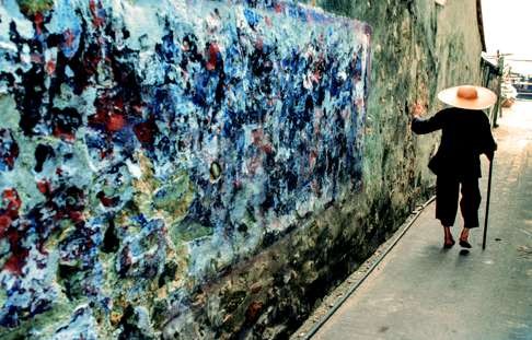 An old woman walks past a wall on the Hong Kong island of Cheung Chau in 1978. Photo: Keith Macgregor