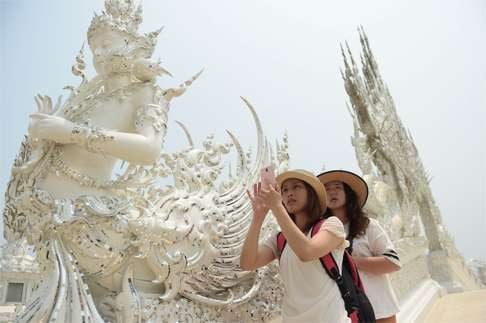 A tourist takes a picture at the White Temple in Chiang Rai, northern Thailand. Chinese tourists are receiving a mixed welcome in the country. Photo: AFP