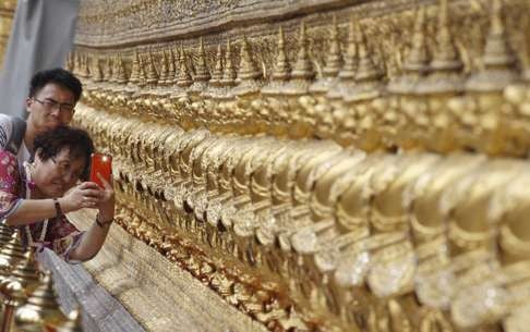 A Chinese tourist takes a picture at Wat Phra Kaeo (the Emerald Buddha Temple) at the Grand Palace in Bangkok. Photo: Reuters