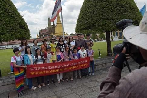 Chinese tourists pose for a group picture outside the Grand Palace in Bangkok. Photo: AFP