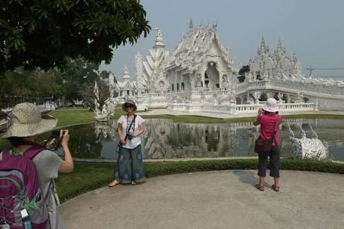 Chinese tourists take pictures at the the White Temple in Chiang Rai, northern Thailand. Photo: AFP