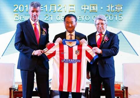 Chairman of Wanda Group Wang Jianlin (centre) holds the jersey presented by Atletico Madrid chairman Enrique Cerezo (right) and CEO Miguel Angel Gil during the agreement signing ceremony in Beijing in January 2015. Photo: Xinhua