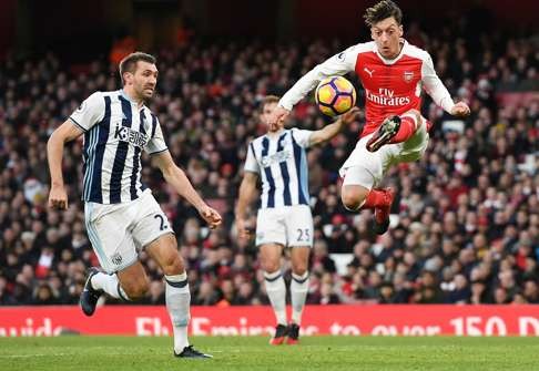 Arsenal's Mesut Ozil (right) vies for the ball with West Bromwich Albion’s Gareth McAuley. Photo: EPA