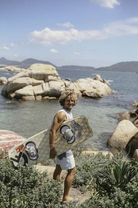 Giovanni Alessi Anghini with his kite-surfing board, a custom piece made by a friend.