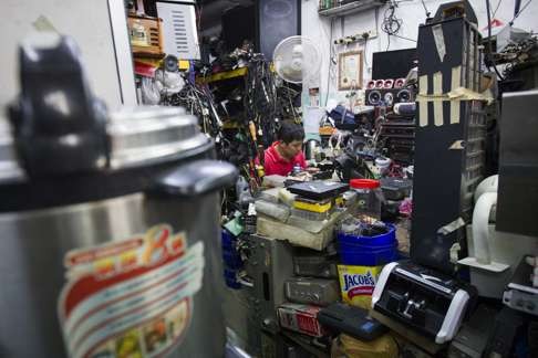 A worker repairs used electronic equipment at a shop in Kuala Lumpur. Photo: AP
