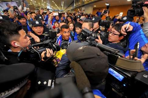 A smiling Tevez is mobbed at the airport. Photo: AFP