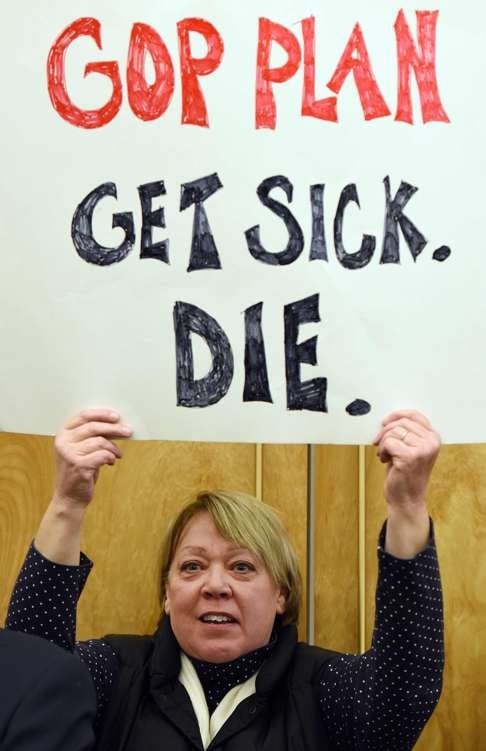 A protester holds a sign during a rally in support of the Affordable Care Act in Denver. Photo: AFP