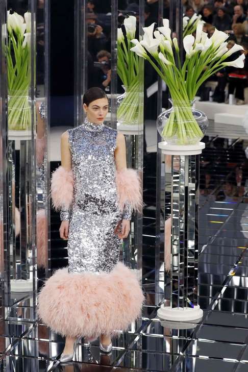 A model presents a creation with baby pink ostrich feather sleeves and dress hem. Photo: AFP