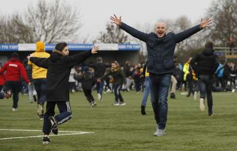 Sutton fans celebrate after the FA Cup win over Leeds United. Photo: AP