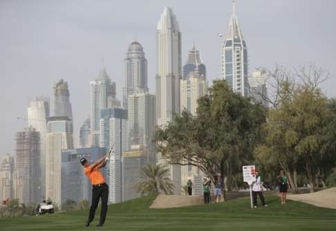 Henrik Stenson of Sweden plays a shot against the magnificent Dubai skyline. Photo: AP