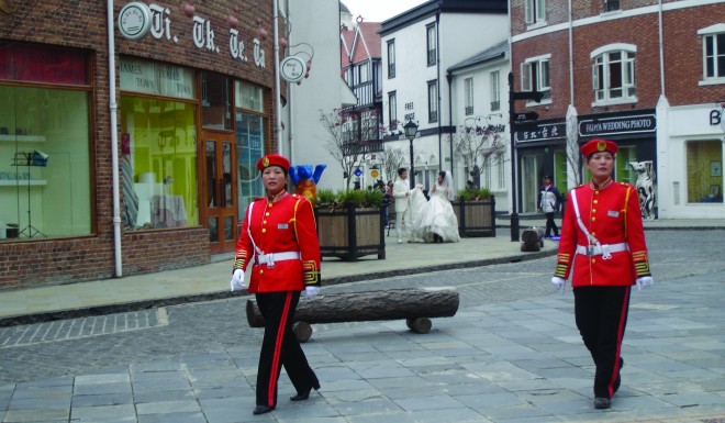 Real estate agencies in Shanghai’s British-inspired Thames Town lure potential buyers with the promise that they can “Dream of England. Live in Thames Town.” Security guards patrolling the property – a mix of Gothic, Tudor and half-timbered buildings –wear uniforms inspired by those of  the Queen’s Foot Guard. Photo credit: Bianca Bosker