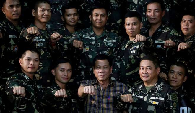 Philippine President Rodrigo Duterte makes a ‘fist bump’, his May presidential elections campaign gesture, with soldiers during a visit at an army Camp Capinpin military camp. Photo: Reuters