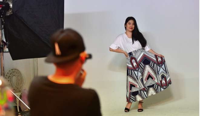 Vivian Geeyang Kim poses for a photo shoot in order to update her online clothing shop at a studio in Seoul. Photo: AFP