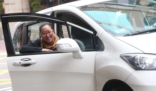 Hong Kong Uber driver Rita Lo with her car at Tsim Sha Tsui in March. Photo: K.Y. Cheng