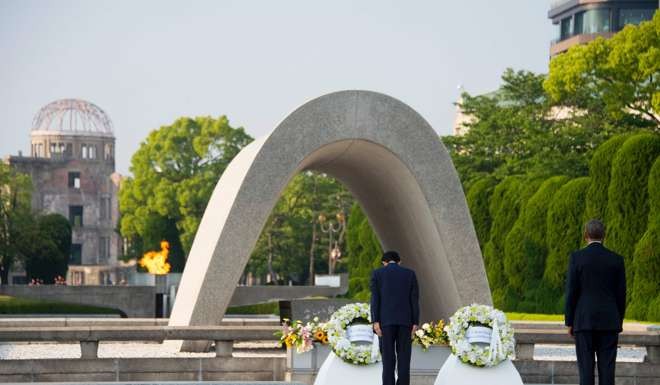 US President Barack Obama, right, looks on as Japanese Prime Minister Shinzo Abe lays a wreath at the Hiroshima Peace Memorial Park in May, 2016. Photo: AFP