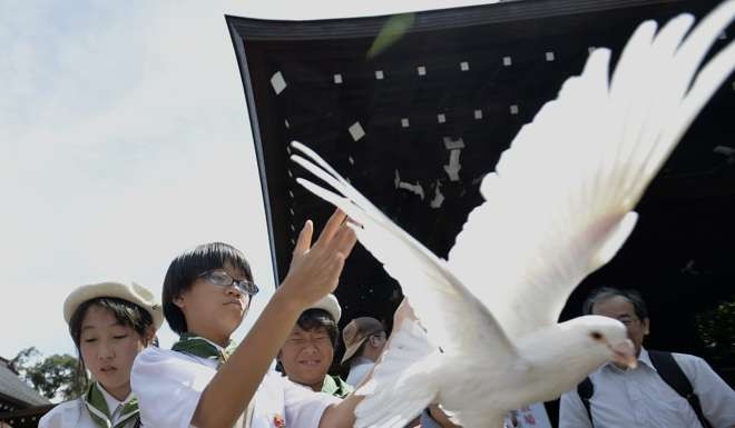 A young girl releases a dove for peace and as a tribute to all the war dead during a ceremony at the Yasukuni Shrine in Tokyo. Photo: EPA